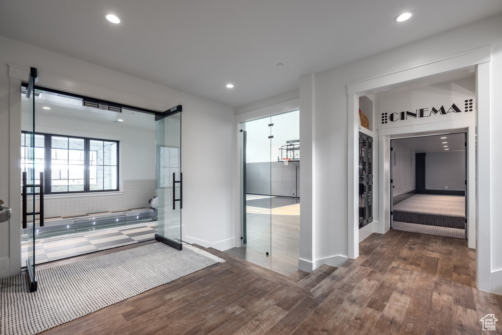 Bathroom featuring wood finished floors, a garden tub, recessed lighting, and baseboards