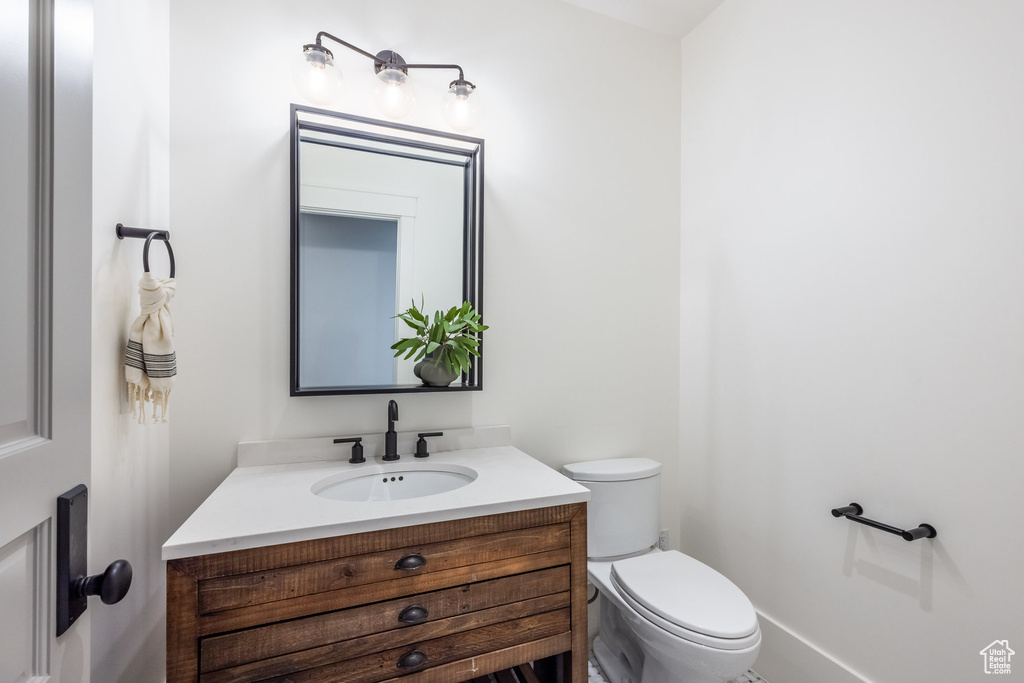 Half bathroom featuring toilet and vanity