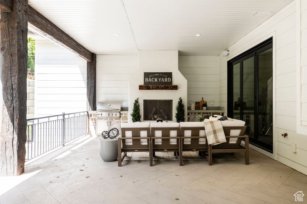 View of patio with a grill and an outdoor living space with a fireplace