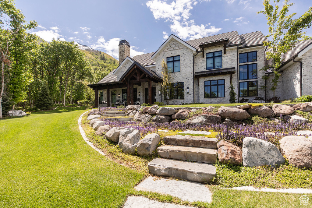 View of front of property featuring a chimney and a front yard