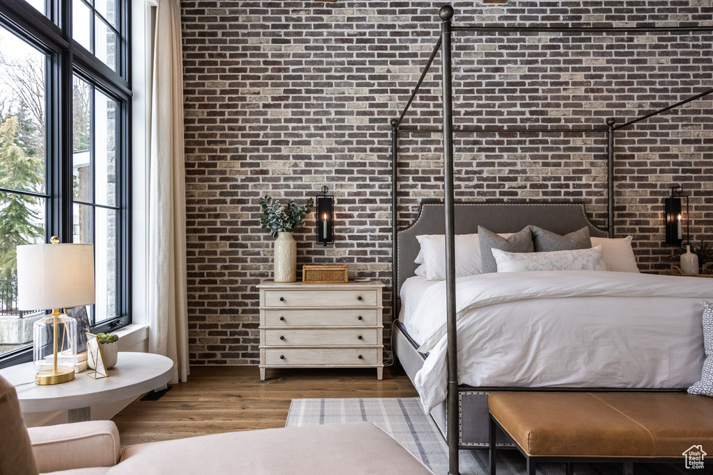 Bedroom with brick wall and wood finished floors