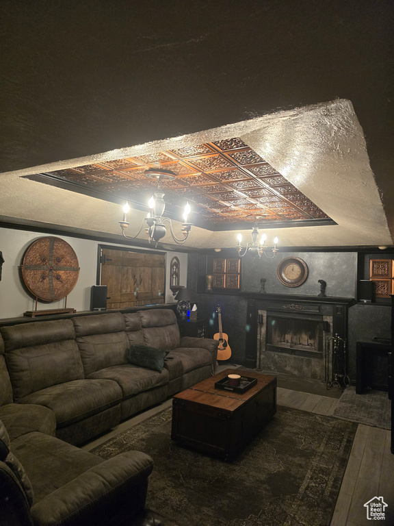 Living room with an ornate ceiling, a fireplace, a tray ceiling, and hardwood / wood-style floors