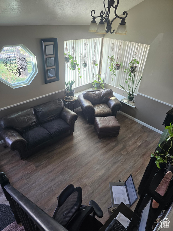 Living area featuring baseboards, wood finished floors, and a textured ceiling
