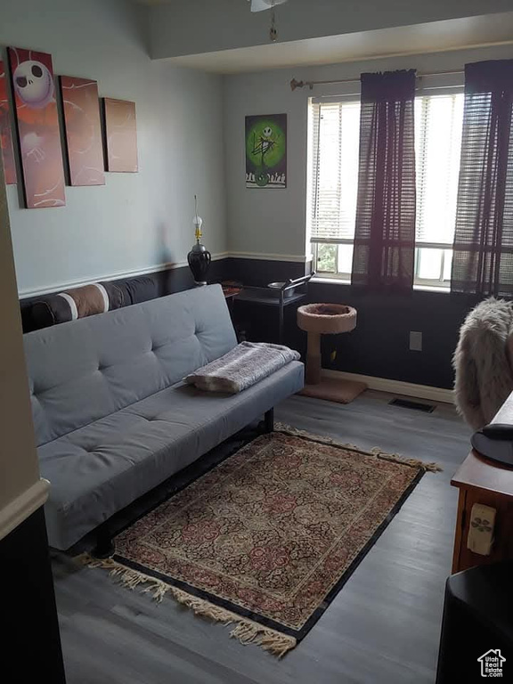 Living area featuring visible vents, baseboards, and wood finished floors
