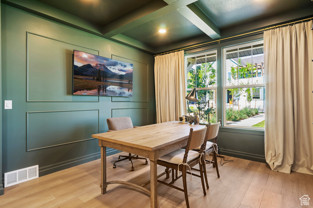 Dining space with coffered ceiling, visible vents, beamed ceiling, and wood finished floors