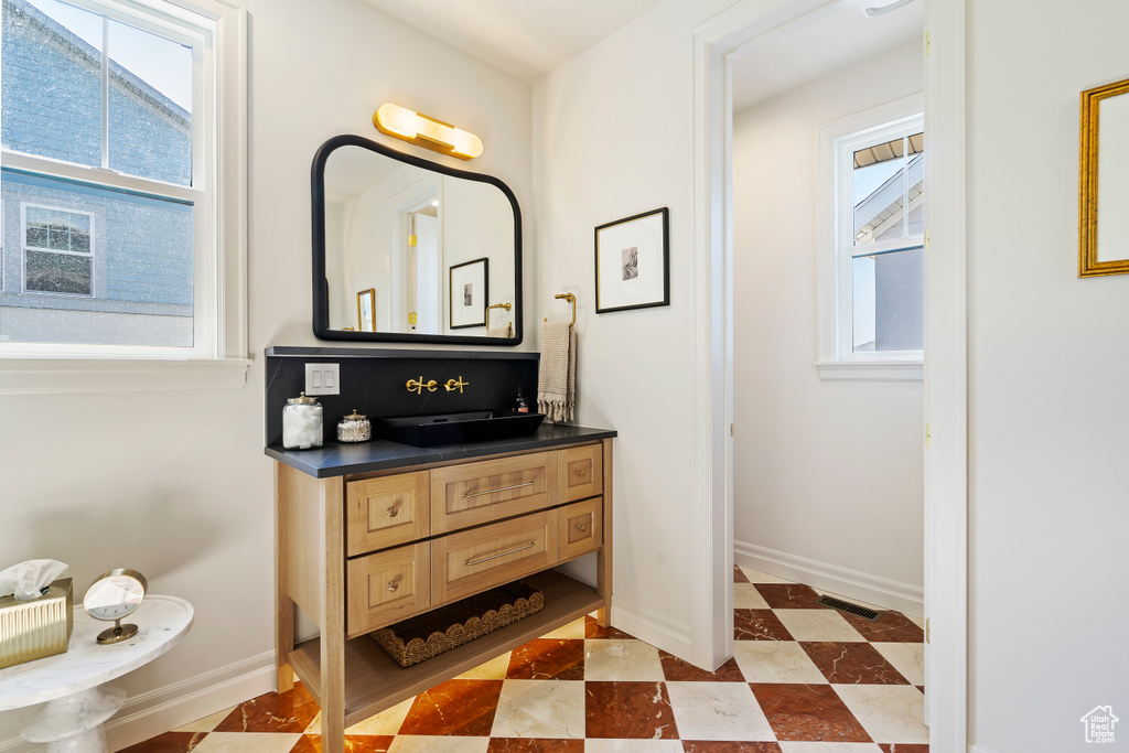 Bathroom featuring plenty of natural light, tile patterned floors, visible vents, and baseboards