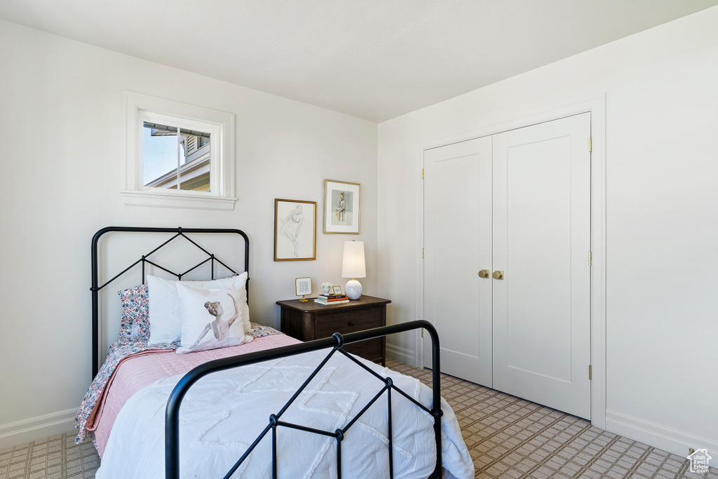 Bedroom with light floors, baseboards, and a closet