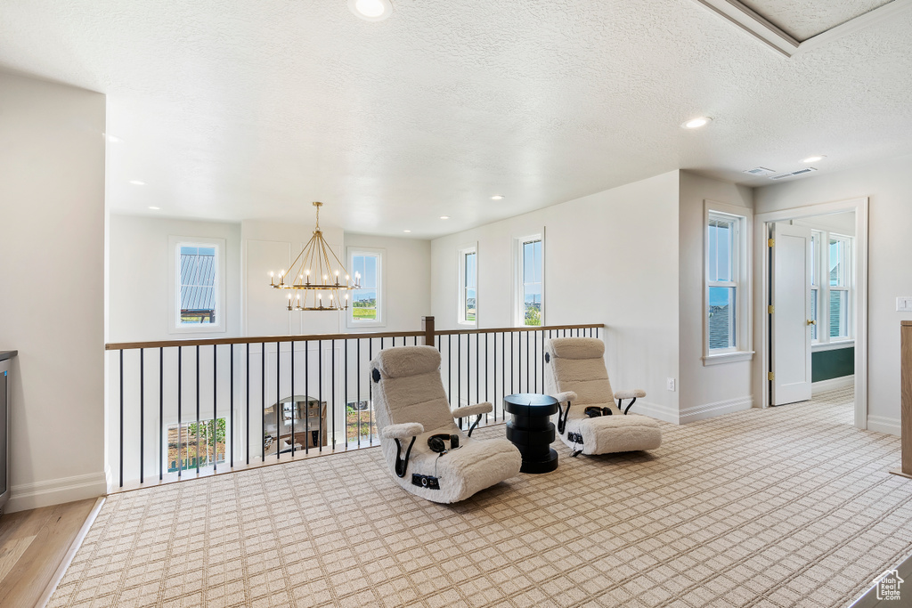 Living area featuring a chandelier, recessed lighting, a textured ceiling, and baseboards