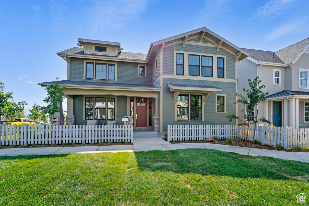 View of front facade featuring a porch and a fenced front yard