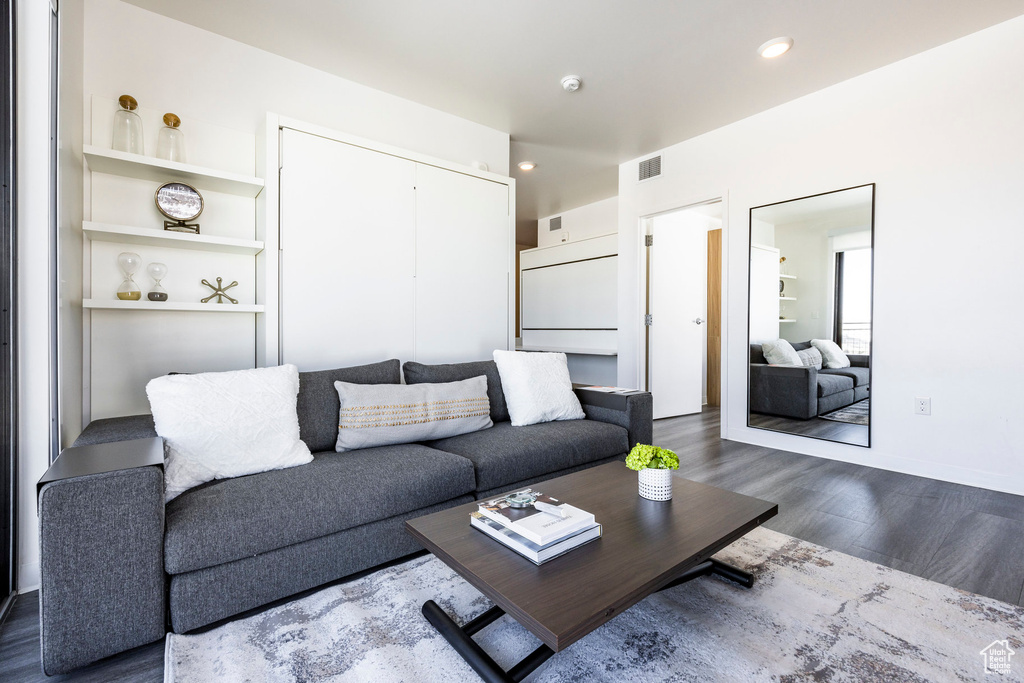 Living area featuring dark wood-style floors and recessed lighting