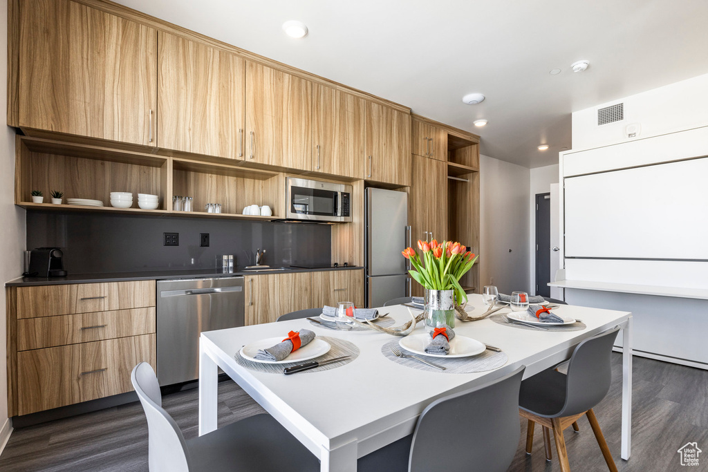 Kitchen with open shelves, appliances with stainless steel finishes, dark wood-type flooring, modern cabinets, and a sink