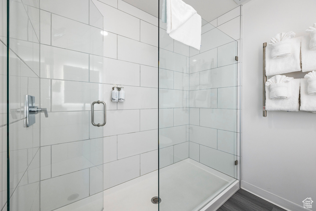 Bathroom featuring a stall shower, baseboards, and wood finished floors