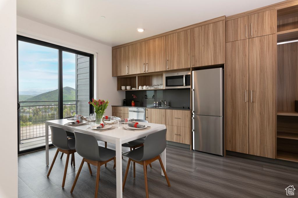 Dining room with a mountain view, dark wood finished floors, and recessed lighting