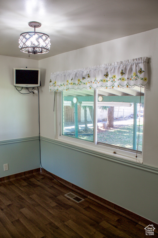 Spare room with baseboards, visible vents, and wood finished floors