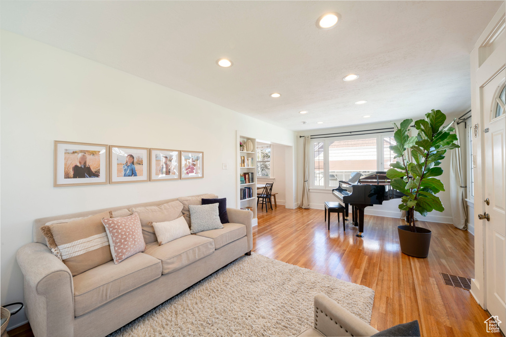 Living area featuring baseboards, light wood-style flooring, visible vents, and recessed lighting