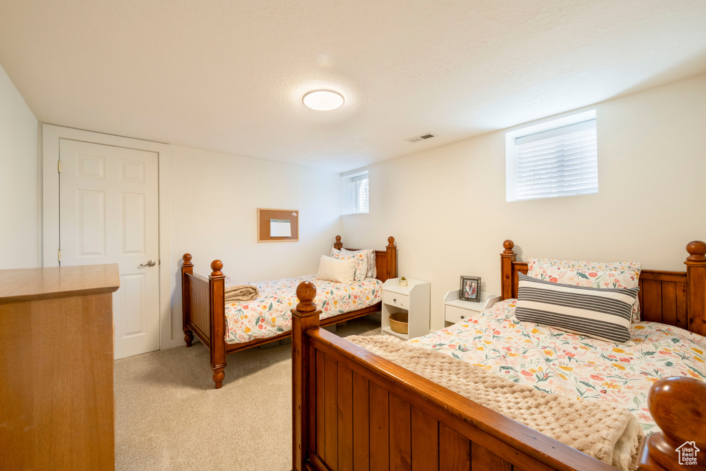 Bedroom with light carpet and visible vents