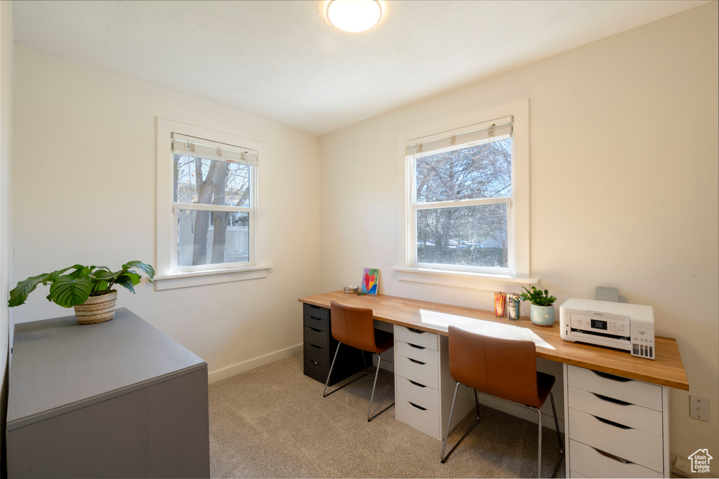 Home office with baseboards and light colored carpet