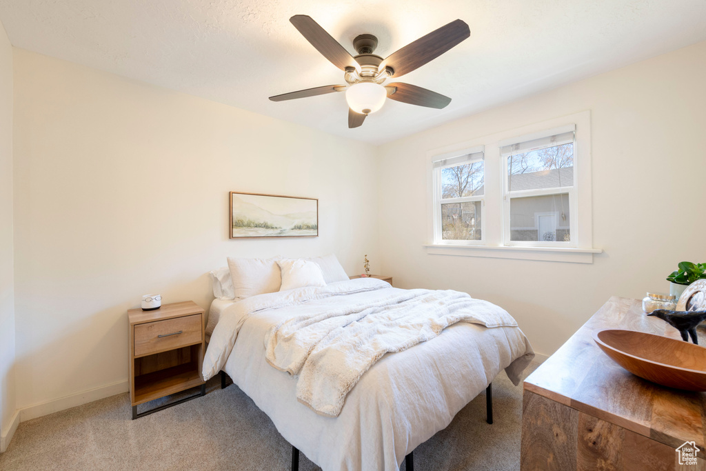 Bedroom with baseboards, carpet floors, and a ceiling fan