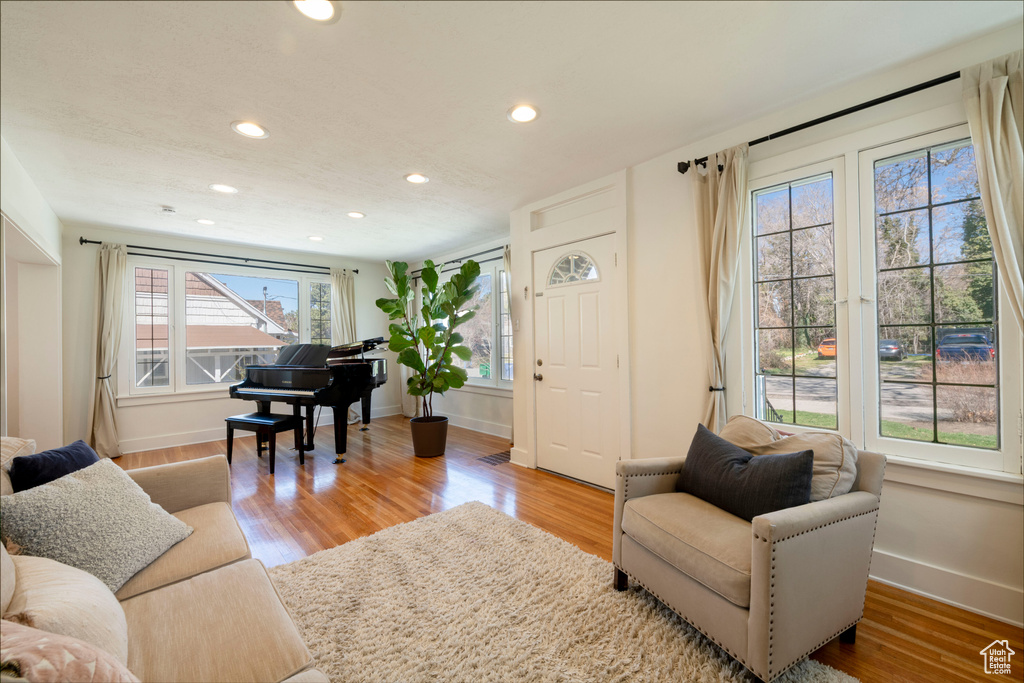 Living area with baseboards, wood finished floors, and recessed lighting