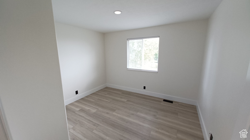 Unfurnished room with baseboards, light wood-type flooring, and recessed lighting