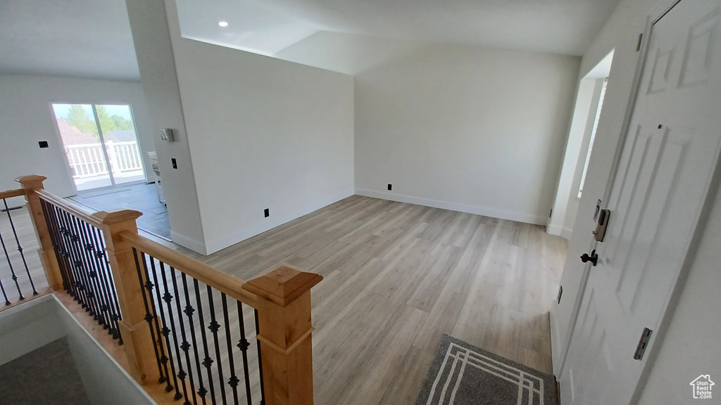 Bonus room with light wood-style flooring, lofted ceiling, and baseboards