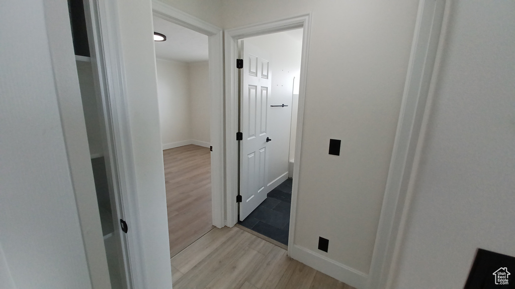 Hall with light wood-style flooring and baseboards