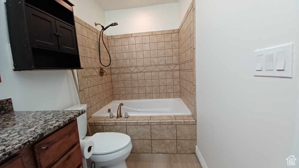 Full bathroom with vanity, toilet, and tiled shower / bath combo
