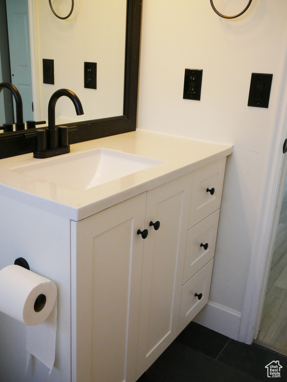Bathroom with vanity, tile patterned floors, and baseboards