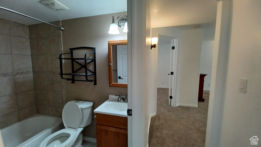 Full bathroom with toilet, vanity,  shower combination, and baseboards