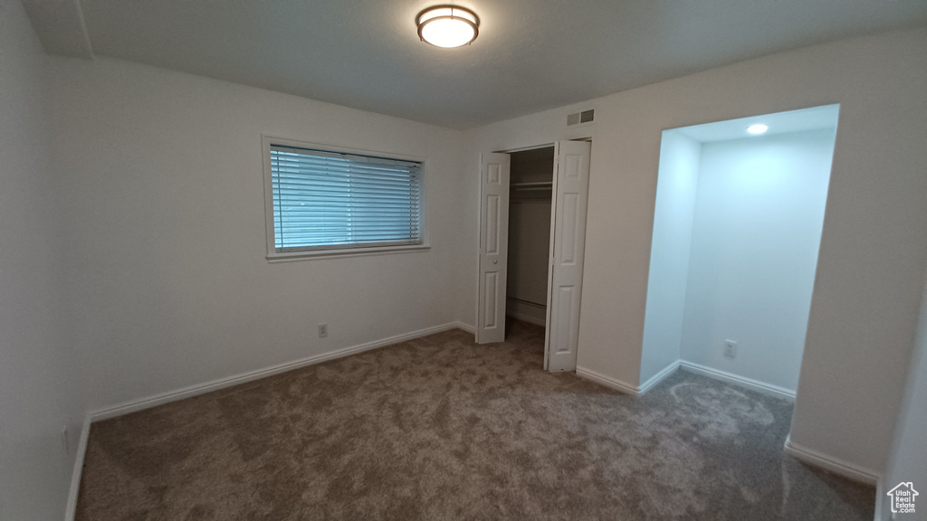 Unfurnished bedroom featuring carpet floors, baseboards, and a closet