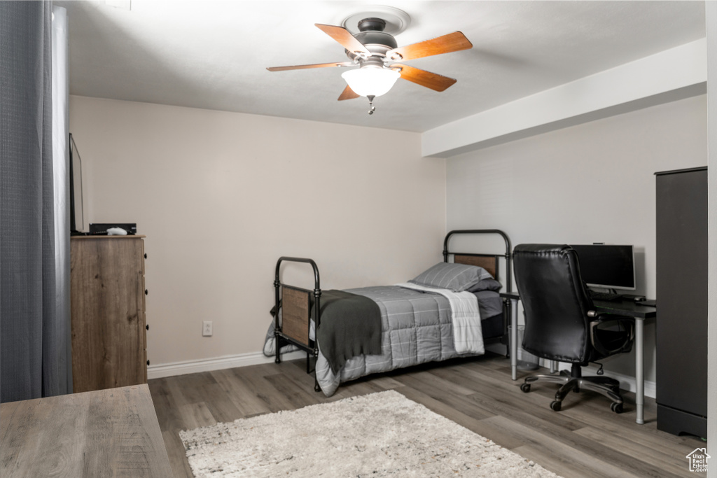 Bedroom featuring a ceiling fan, baseboards, and wood finished floors