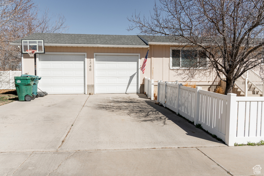 Garage featuring driveway and fence
