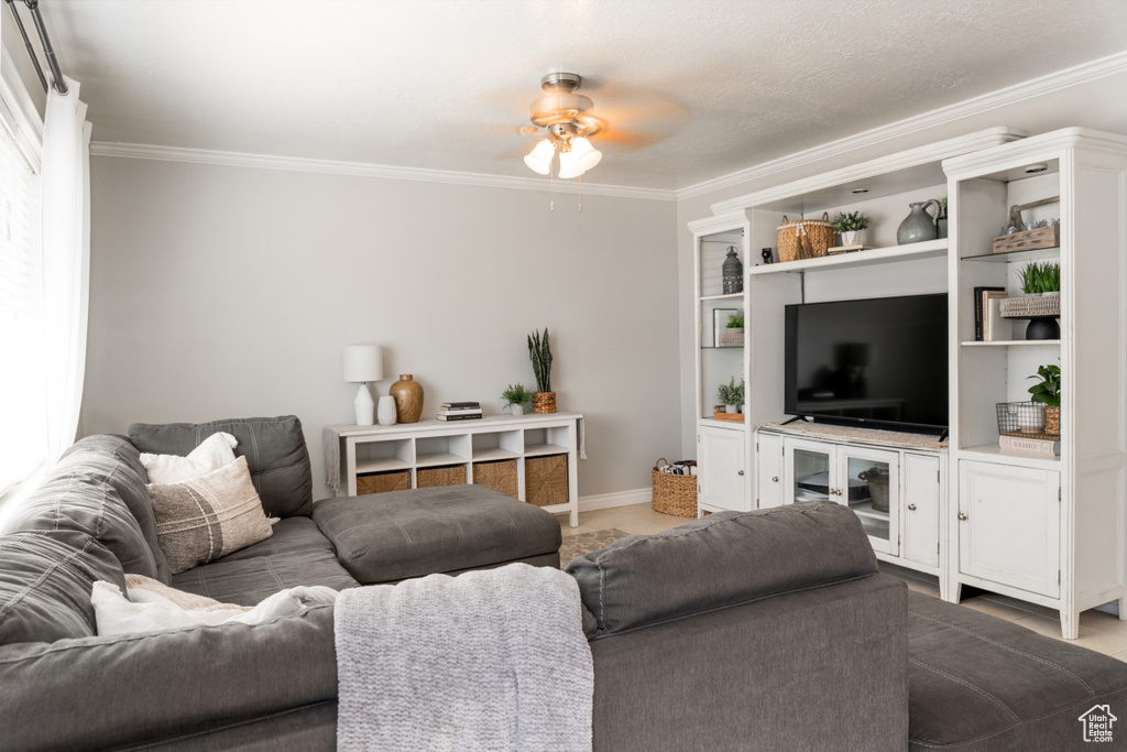 Living area featuring baseboards, ceiling fan, and ornamental molding