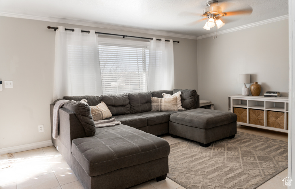 Living room with light tile patterned flooring, baseboards, ornamental molding, and a ceiling fan