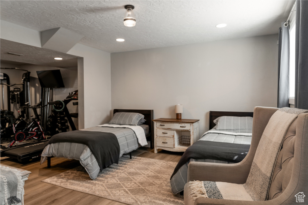 Bedroom with recessed lighting, a textured ceiling, and wood finished floors