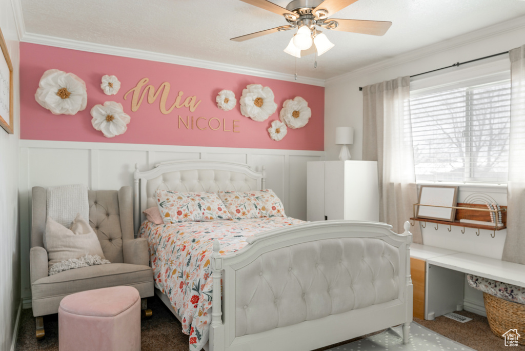 Bedroom featuring a wainscoted wall, crown molding, and ceiling fan