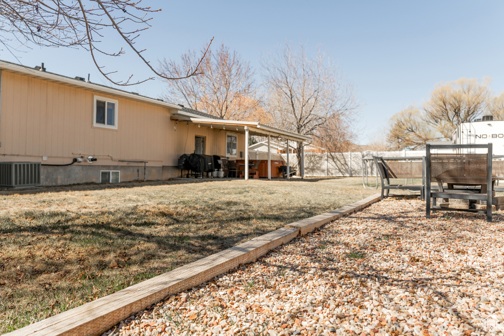 View of yard featuring cooling unit and fence