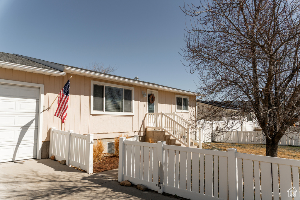 View of front of home with an attached garage and fence private yard