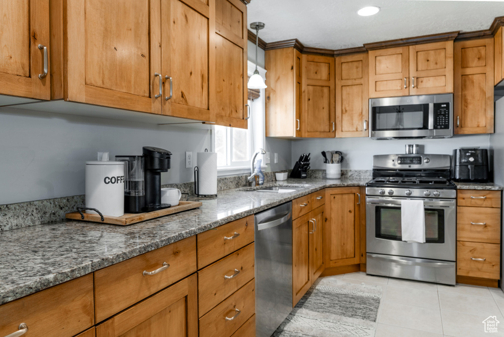 Kitchen featuring a sink, stainless steel appliances, and brown cabinetry