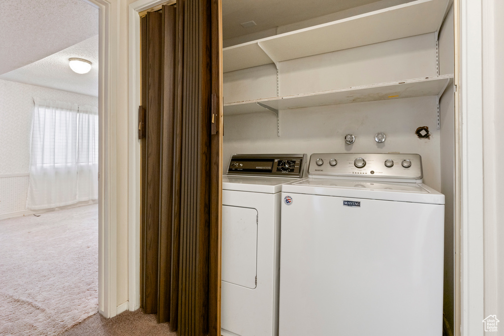 Laundry room with washer and dryer, laundry area, and carpet flooring
