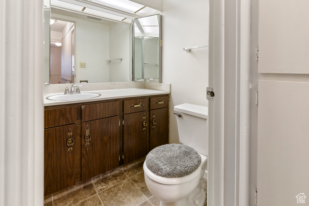 Half bathroom with toilet, vanity, and visible vents