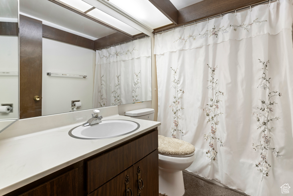 Bathroom with a shower with curtain, toilet, and vanity