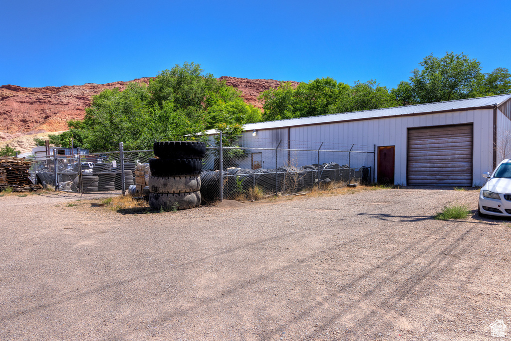 View of outbuilding featuring an outbuilding, a mountain view, and fence