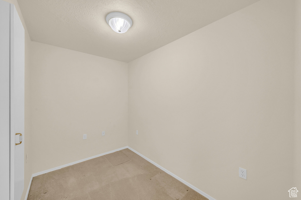 Spare room featuring light carpet and a textured ceiling