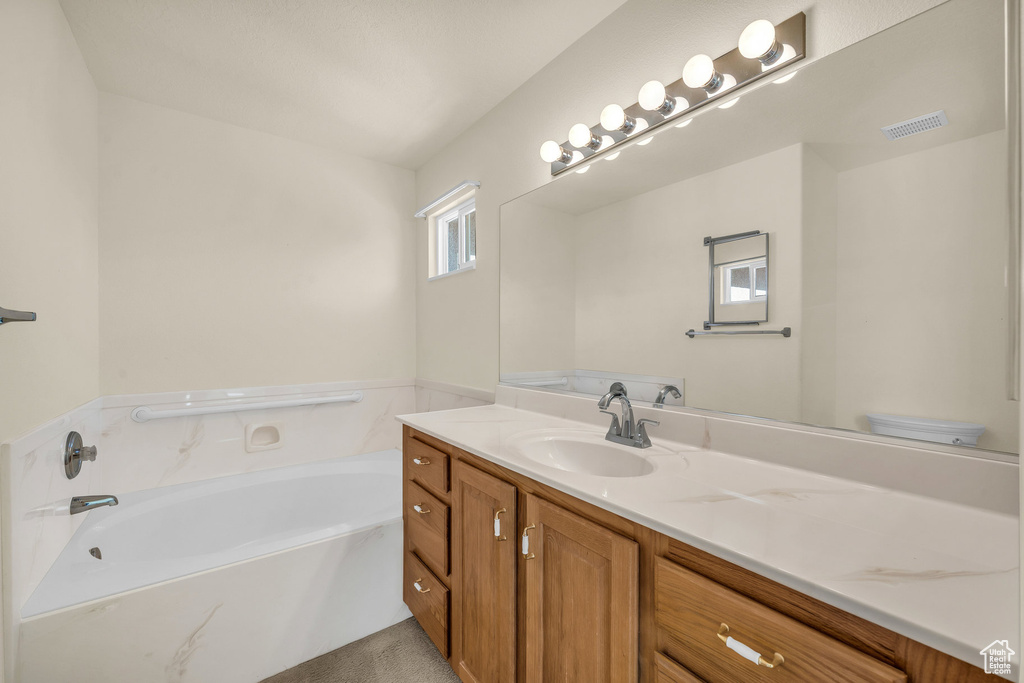 Full bathroom with vanity and a garden tub