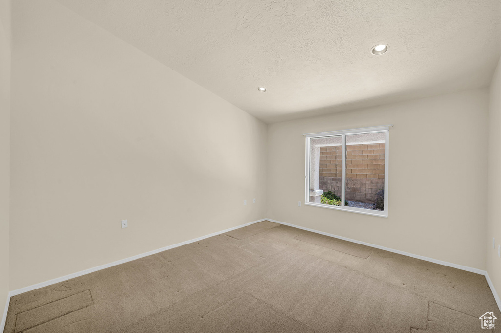 Spare room featuring carpet, recessed lighting, and a textured ceiling