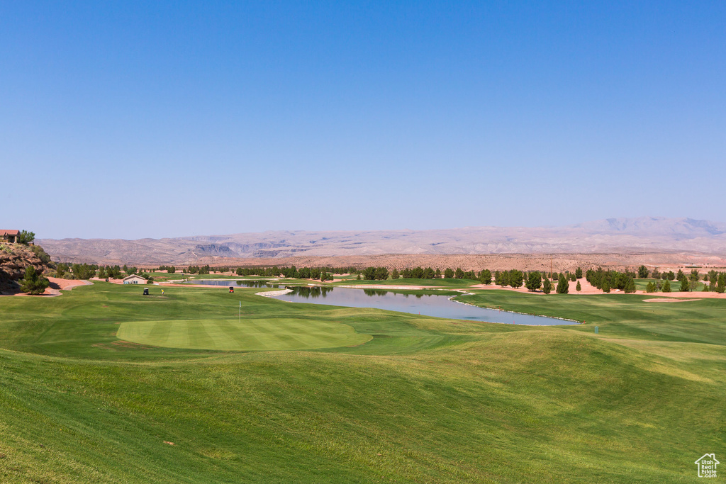 View of community featuring a water and mountain view, a yard, and golf course view