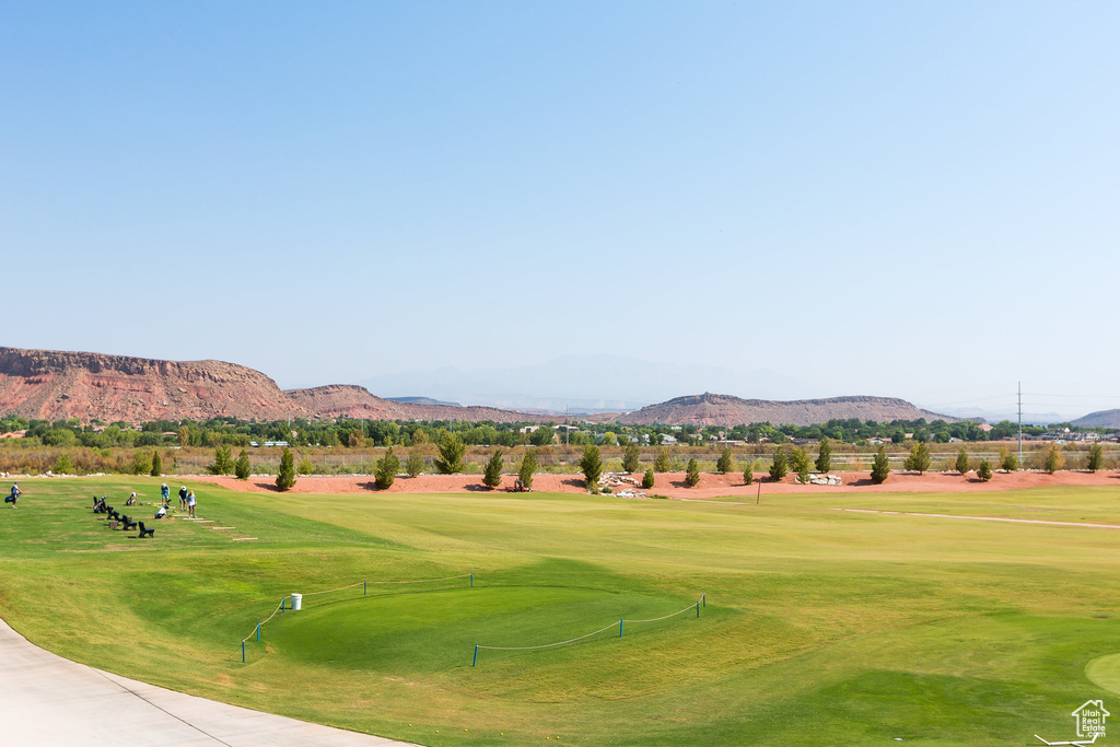 View of community with a mountain view, view of golf course, and a lawn
