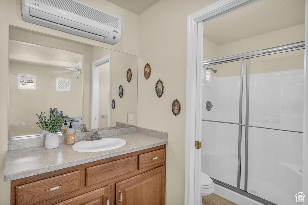 Full bathroom with a wall mounted air conditioner, a shower stall, vanity, and a ceiling fan
