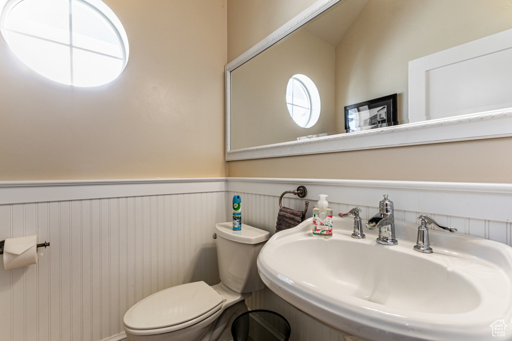 Half bathroom with a sink and wainscoting